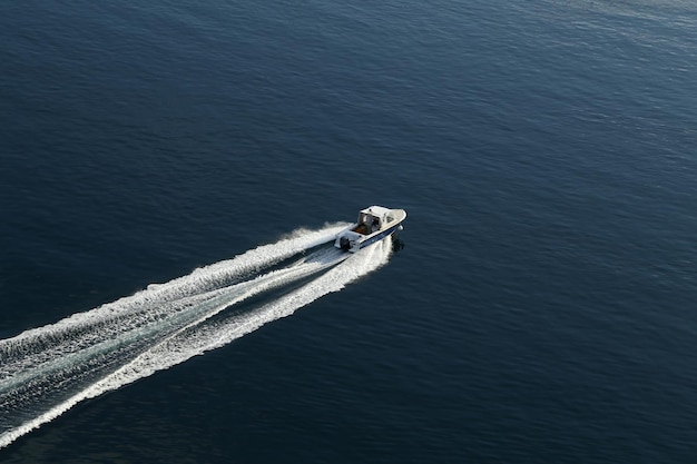 Prise de vue en grand angle d'un bateau de pêche laissant un sentier sur l'eau