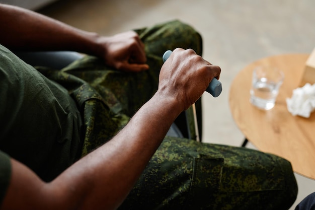 Prise de vue en grand angle d'un soldat noir méconnaissable qui ressent de la tension lorsqu'il parle de son problème mental