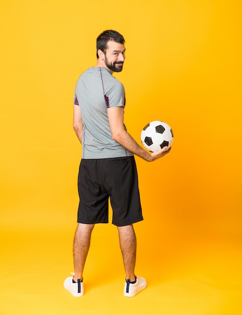 Prise de vue d'un homme de joueur de football sur jaune isolé