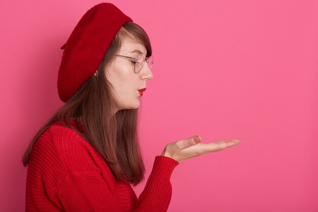 Prise de vue horizontale de jeune femme séduisante souffle baiser d'air