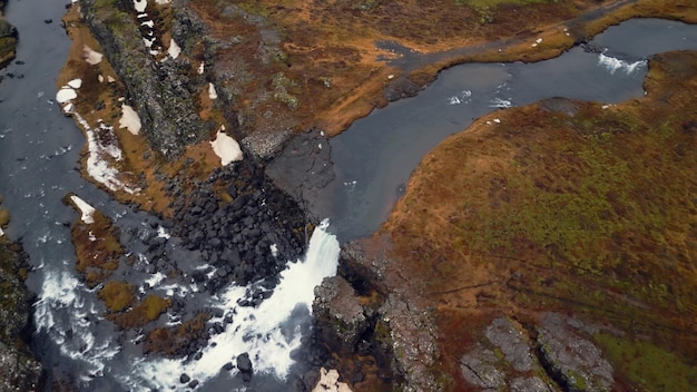 Une prise de vue par drone de la cascade nordique d'Islande, un énorme ruisseau d'eau s'écoulant des falaises formant une magnifique cascade d'oxarafoss.