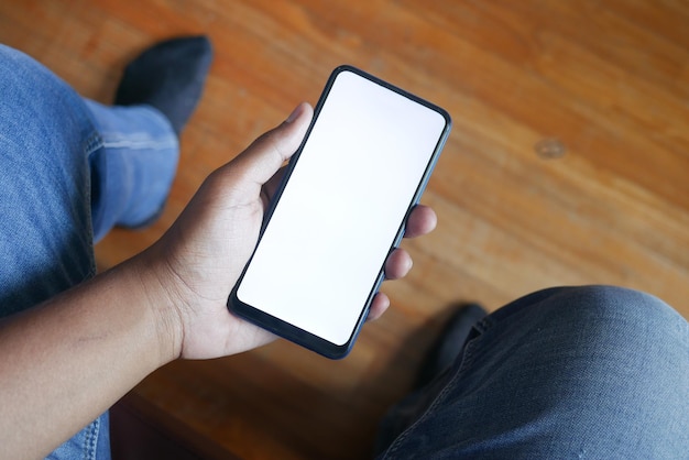 Prise de vue en POV tenant un téléphone intelligent assis sur une chaise