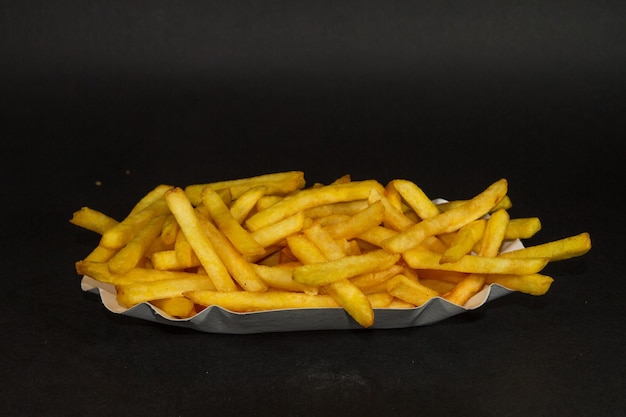 Une prise de vue rapprochée de délicieuses frites sur un fond noir