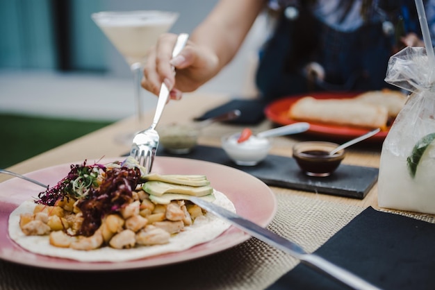 Une prise de vue sélective de la femelle mangeant un plat avec du chou rouge, de l'avocat et de la viande