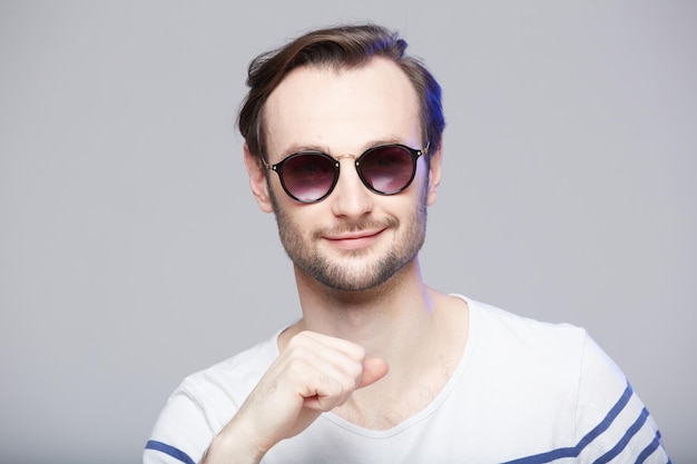 Prise de vue en studio d'un bel homme portant des lunettes de soleil