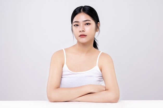 Photo prise de vue en studio d'une belle jeune femme asiatique avec une peau fraîche et propre sur fond blanc soins du visage traitement du visage cosmétologie beauté et spa