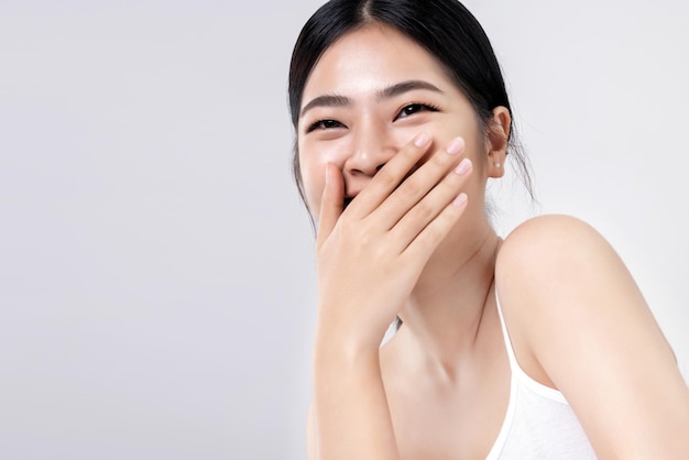 Photo prise de vue en studio d'une belle jeune femme asiatique avec une peau fraîche et propre sur fond blanc soins du visage traitement du visage cosmétologie beauté et spa