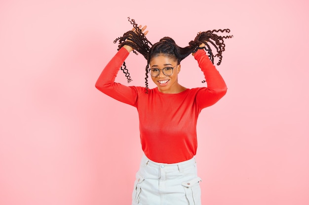 Prise de vue en studio d'une charmante jeune femme heureuse avec une coupe de cheveux afro isolée sur fond rose avec un espace vide pour votre contenu promotionnel Émotions agréables