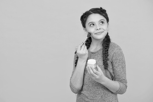 Prise de vue en studio d'une jeune fille faisant du maquillage belle adolescente faisant du maquillage à l'aide d'un pinceau à poudre