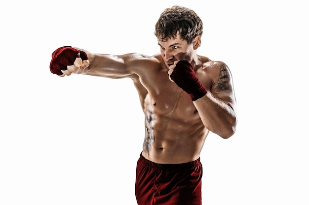 Prise de vue en studio d'un kickboxeur qui s'entraîne à pratiquer le jab sur fond blanc vêtements de sport rouges