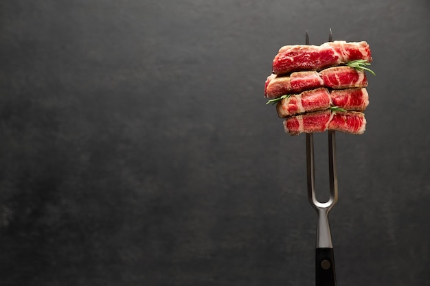 Prise de vue en studio de tranches de steak sur une fourchette à viande