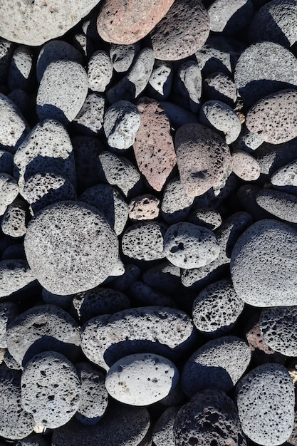 Une prise de vue verticale de roches de lave arrondies sur la plage de Kona, à Hawaï, parfaite pour l'arrière-plan