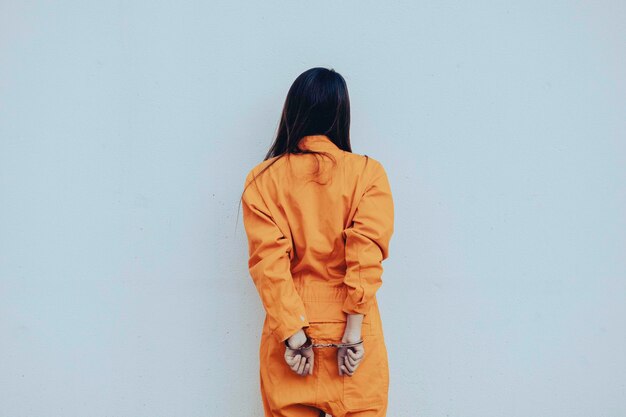 Prisonnier en robe orange conceptPortrait de femme asiatique en uniforme de prison sur fond blanc