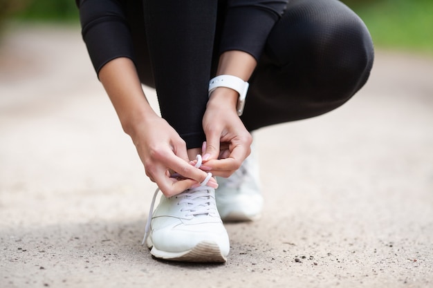 Problème de baskets, une coureuse attachant ses chaussures en préparation pour un jogging