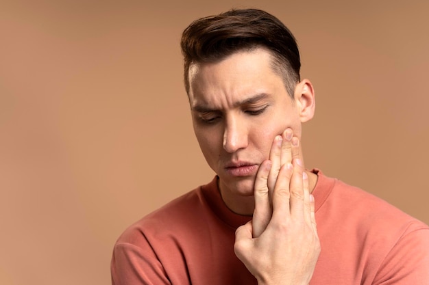 Problèmes dentaires Portrait d'un homme malsain appuyant sur la joue endolorie souffrant de maux de dents aigus