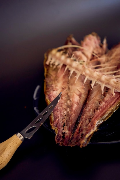 Photo le procédé de dissection du maquereau doré fumé à chaud avec de petits couteaux