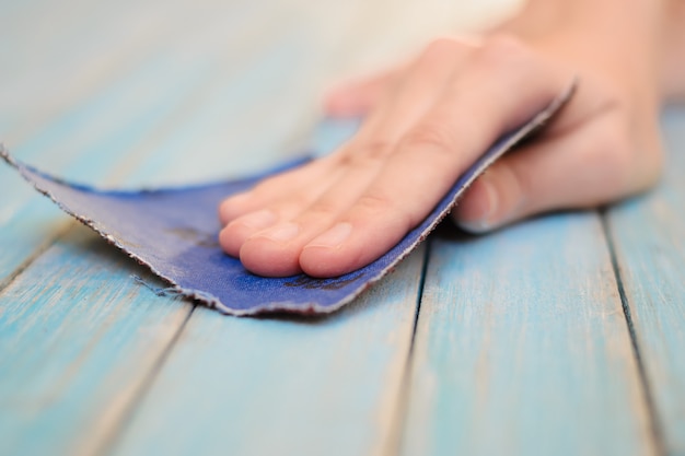 Procédé de polissage à la main de la surface d'une planche de bois avec un papier abrasif