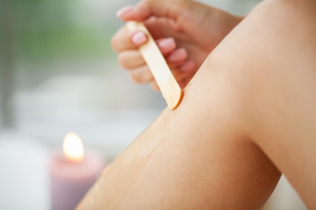 Procédure d'épilation avec bande de cire sur les jambes