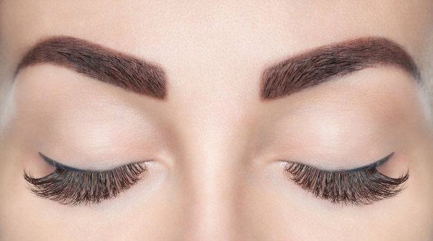 Photo procédure d'extension des cils. belle femme aux longs cils dans un salon de beauté