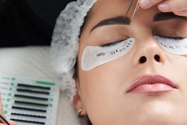 Procédure d'extension de cils close up belle femme avec de longs cils dans un salon de beauté