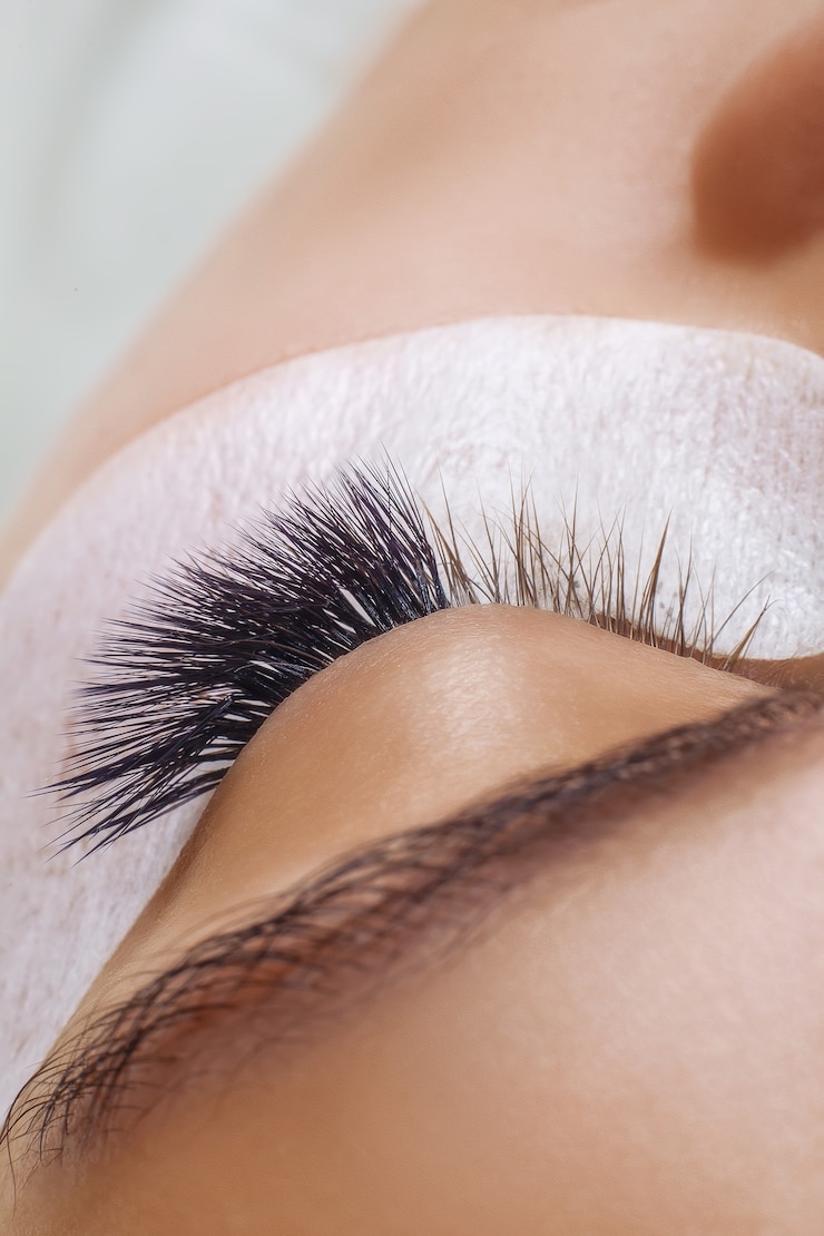 Photo procédure d'extension de cils oeil de femme avec de longs cils bleus effet ombre close up selective focus