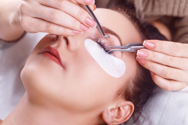 Procédure d'extension des cils. Oeil de femme avec de longs cils. Cils avec strass. Cils, gros plan