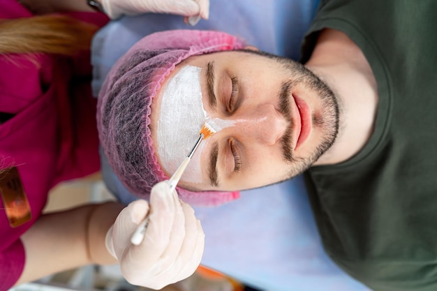 Photo procédure sur le front. homme chez cosmétologue. mésothérapie, plasmolifting. injections de botox. fermer.