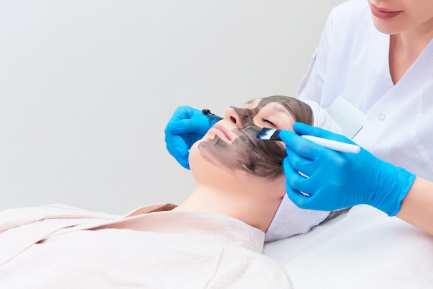 Procédure de gommage facial au carbone dans la clinique de cosmétologie laser.