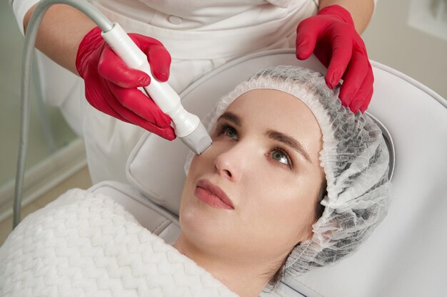 Procédure de levage dans un salon de beauté resserrement et rajeunissement de la peau du visage féminin avec levage