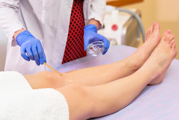 Procédure de mise en forme sur les jambes dans le salon de beauté de la partie du corps