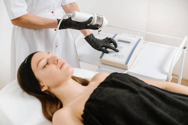 Procédure de nettoyage par ultrasons du visage dans un salon de beauté. Équipement de peau à ultrasons moderne