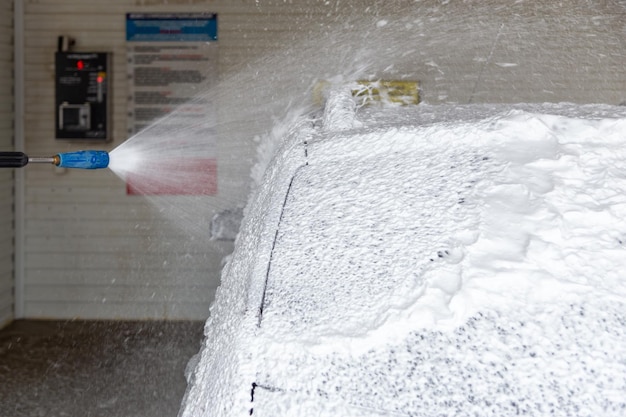 Un processus d'application de savon sud dans la station de lavage de voiture en gros plan avec mise au point sélective