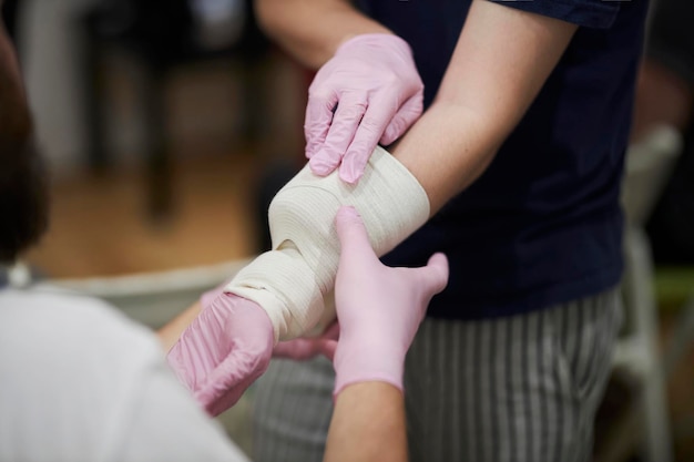 Processus de bandage à la main. Formation aux premiers secours pour les personnes.