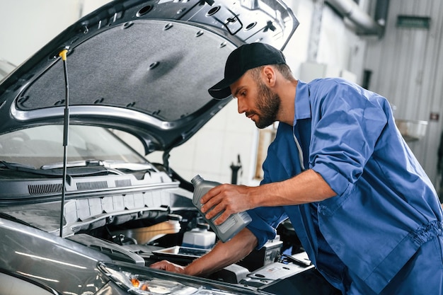 Processus de changement d'huile Mécanicien automobile travaillant dans un garage Service de réparation