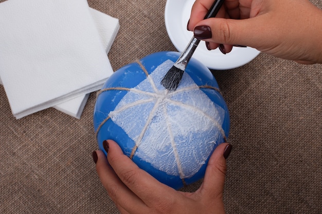 Le processus de collage de serviettes sur un ballon, créant une citrouille à partir de papier mâché.