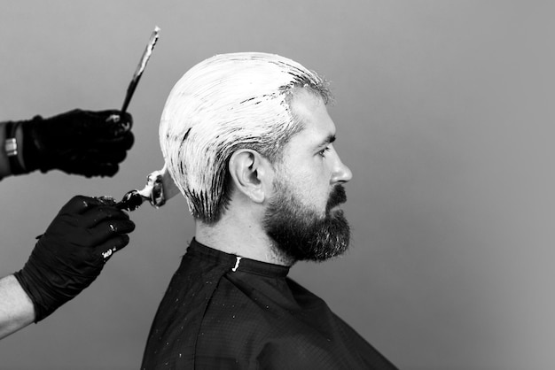 Processus de coloration des cheveux d'un homme barbu au salon de coiffure