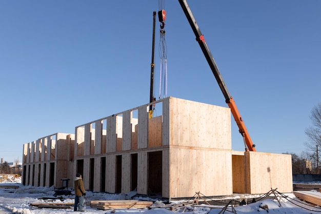 Le processus de construction d'une maison modulaire moderne faite de panneaux composites SIP lors d'une journée d'hiver ensoleillée