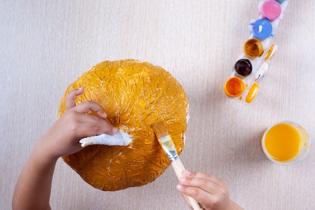 le processus de création d'une citrouille à partir de papier mâché pour la décoration d'Halloween, le dessin de peinture, la surface de jute