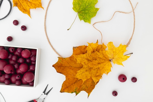 Le processus de création d'une couronne d'automne faite de feuilles jaunes sur le tableau blanc