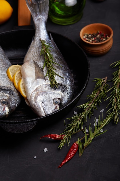 Processus de cuisson du poisson dorado avec du citron et des herbes.