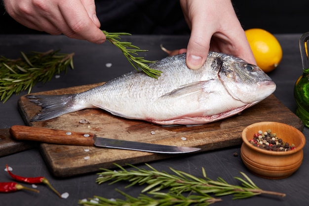 Processus de cuisson du poisson dorado avec du citron et des herbes.