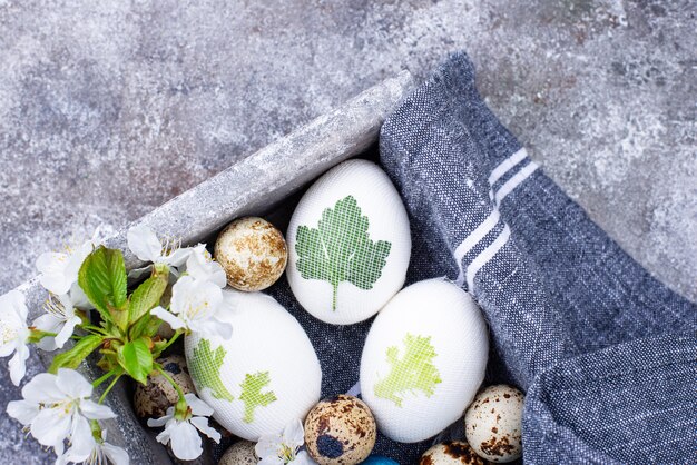 Processus de décoration des œufs de Pâques avec un colorant naturel et des feuilles de plantes