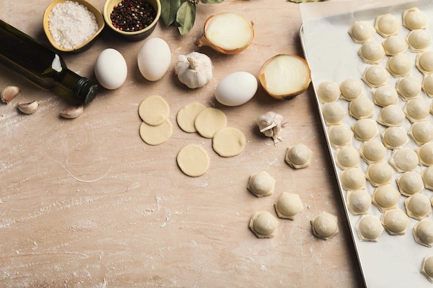 Processus de fabrication de boulettes avec de la viande sur une table en bois. Pelmeni et ingrédients non cuits faits maison.