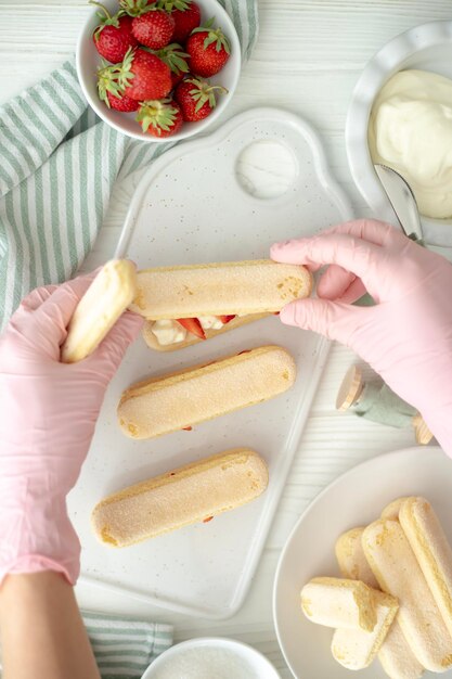 Le processus de fabrication d'un dessert à base de biscuits de Savoie, de fraises et de crème au beurre