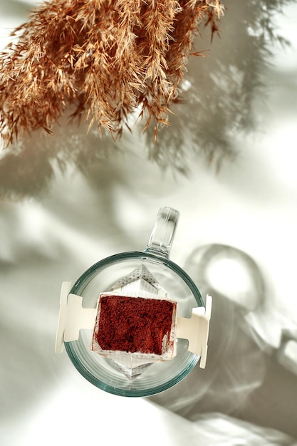 Le processus de fabrication du café goutte à goutte dans un verre transparent. Petit déjeuner matinal ensoleillé. Le filtre à café