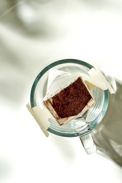 Le processus de fabrication du café goutte à goutte dans un verre transparent. Petit déjeuner matinal ensoleillé. Le filtre à café