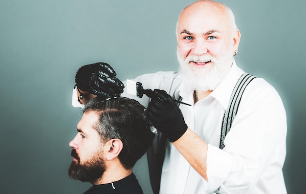 Processus d'un gars qui se fait teindre les cheveux chez le coiffeur Coloration des cheveux homme contre les cheveux gris Coiffeur senior professionnel séchant les cheveux