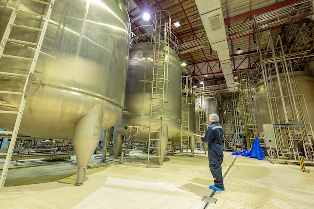 Processus d'inspection du travail masculin cave à lait en poudre à l'usine de réservoirs verticaux en acier inoxydable