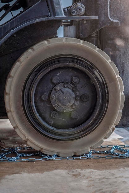 Le processus d'installation d'une chaîne antidérapante sur une roue en hiver pour préparer un tracteur ou un camion chargeur