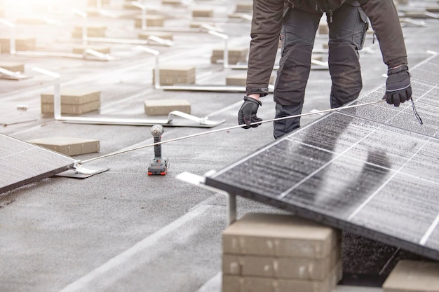 Le processus d'installation des panneaux solaires, l'installateur mesure la distance entre le module de panneau solaire